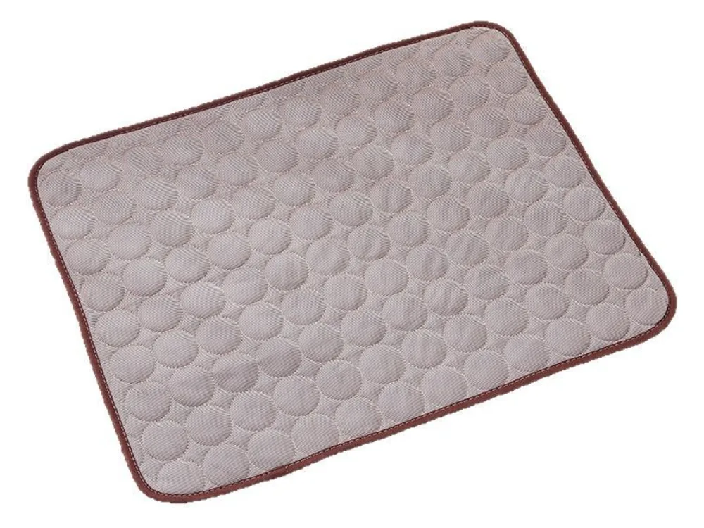Grey cooling mat with a quilted circle pattern and a brown edge.