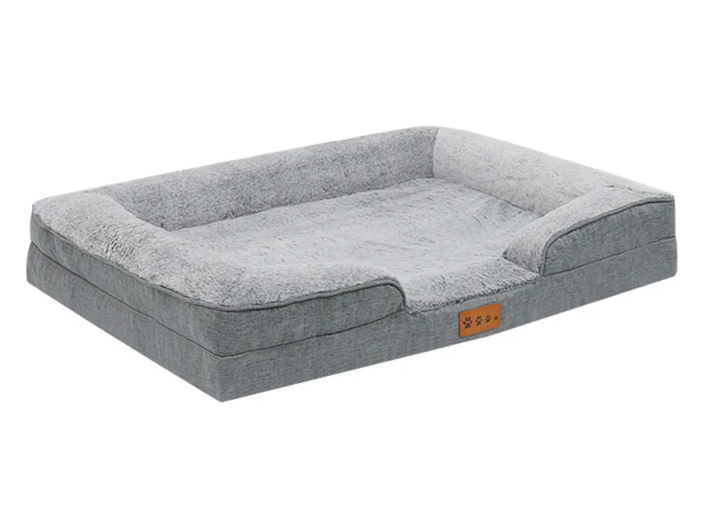 Grey dog bed with a raised bolster on three sides and a low open front.