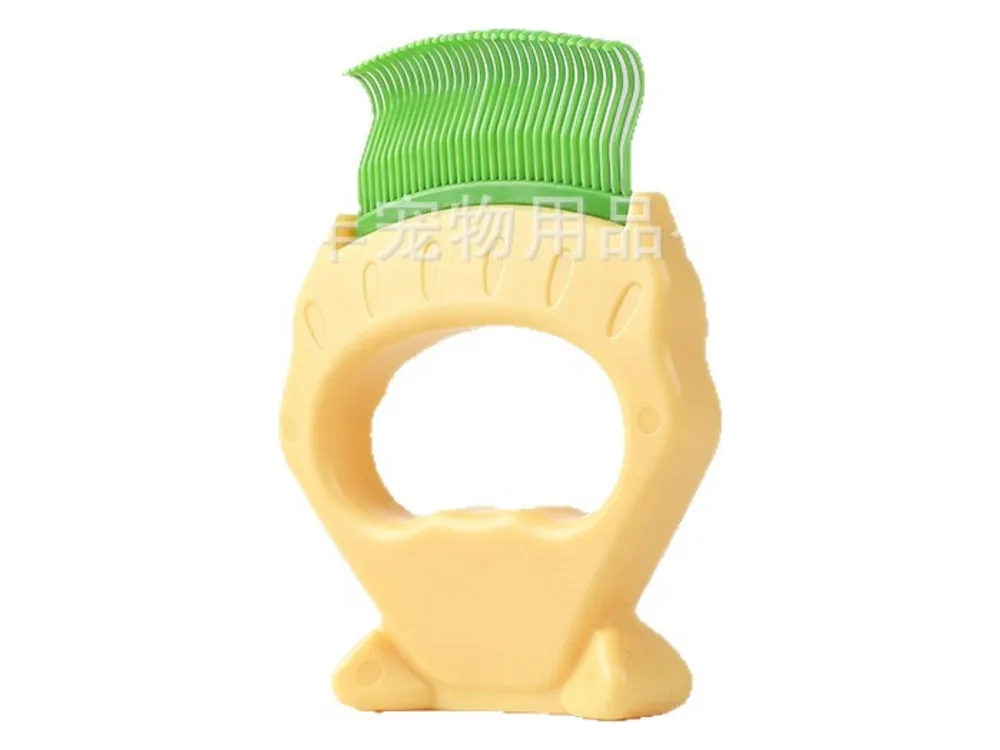 Yellow shell-shaped comb with green curved teeth and a finger hole in the handle.